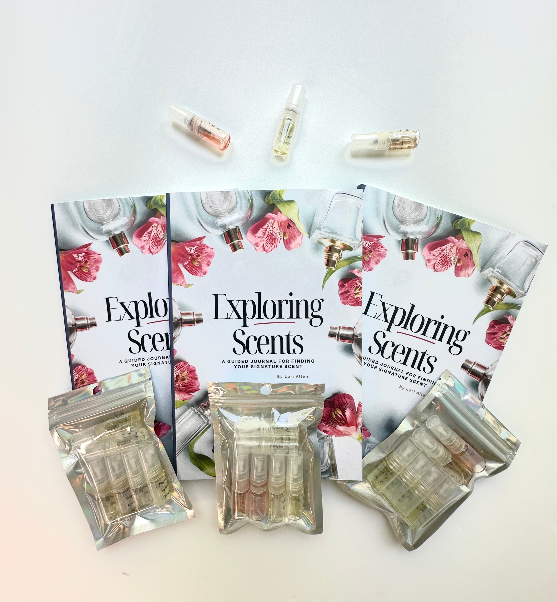 Three Exploring Scents books and three hologram packages of fragrance samples.